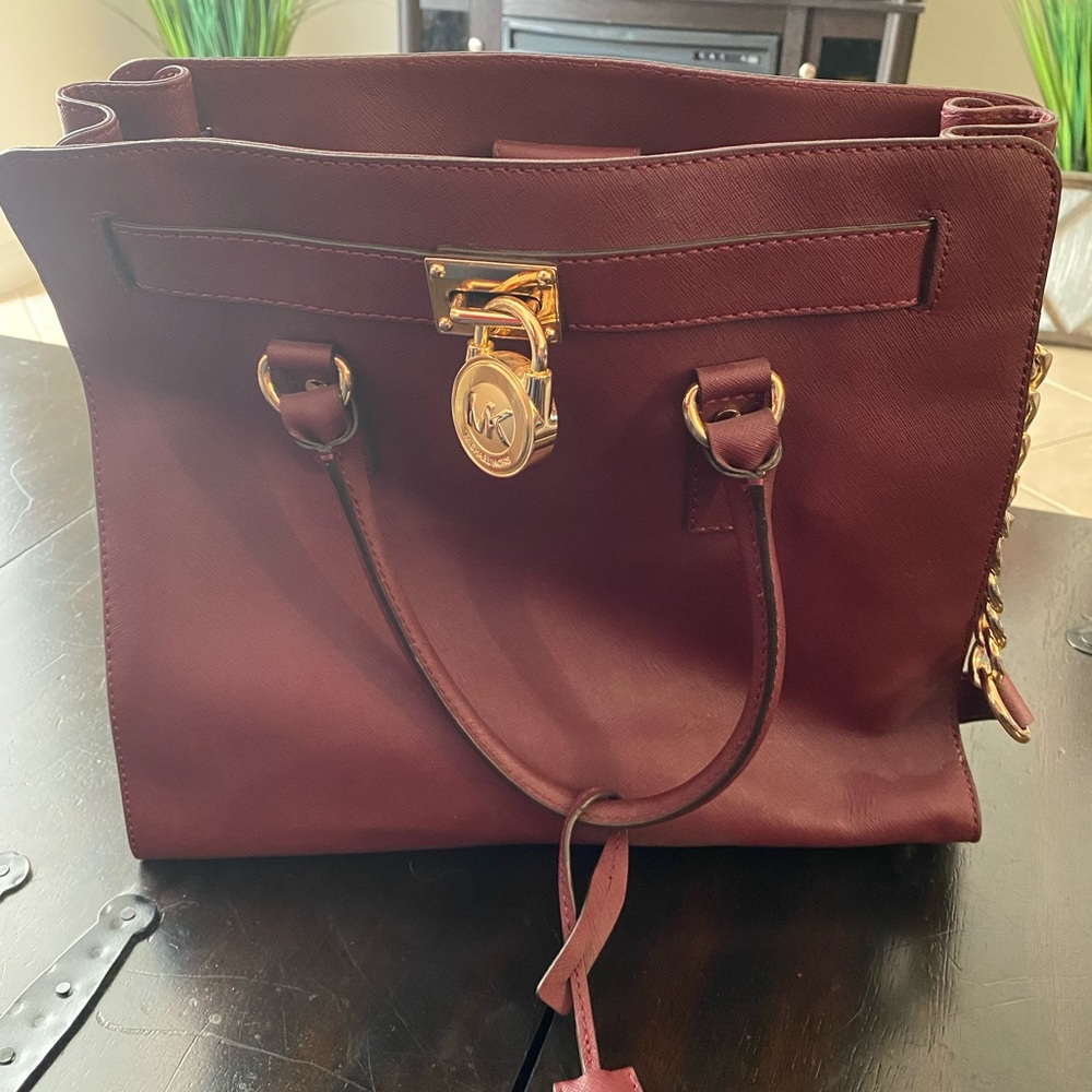 Michael Kors burgundy bag with gold hardware.